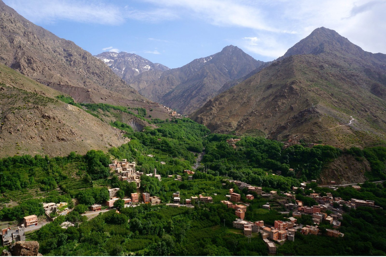 Hikers trekking through the scenic Imlil Valley towards Toubkal Base Camp in the Moroccan High Atlas Mountains