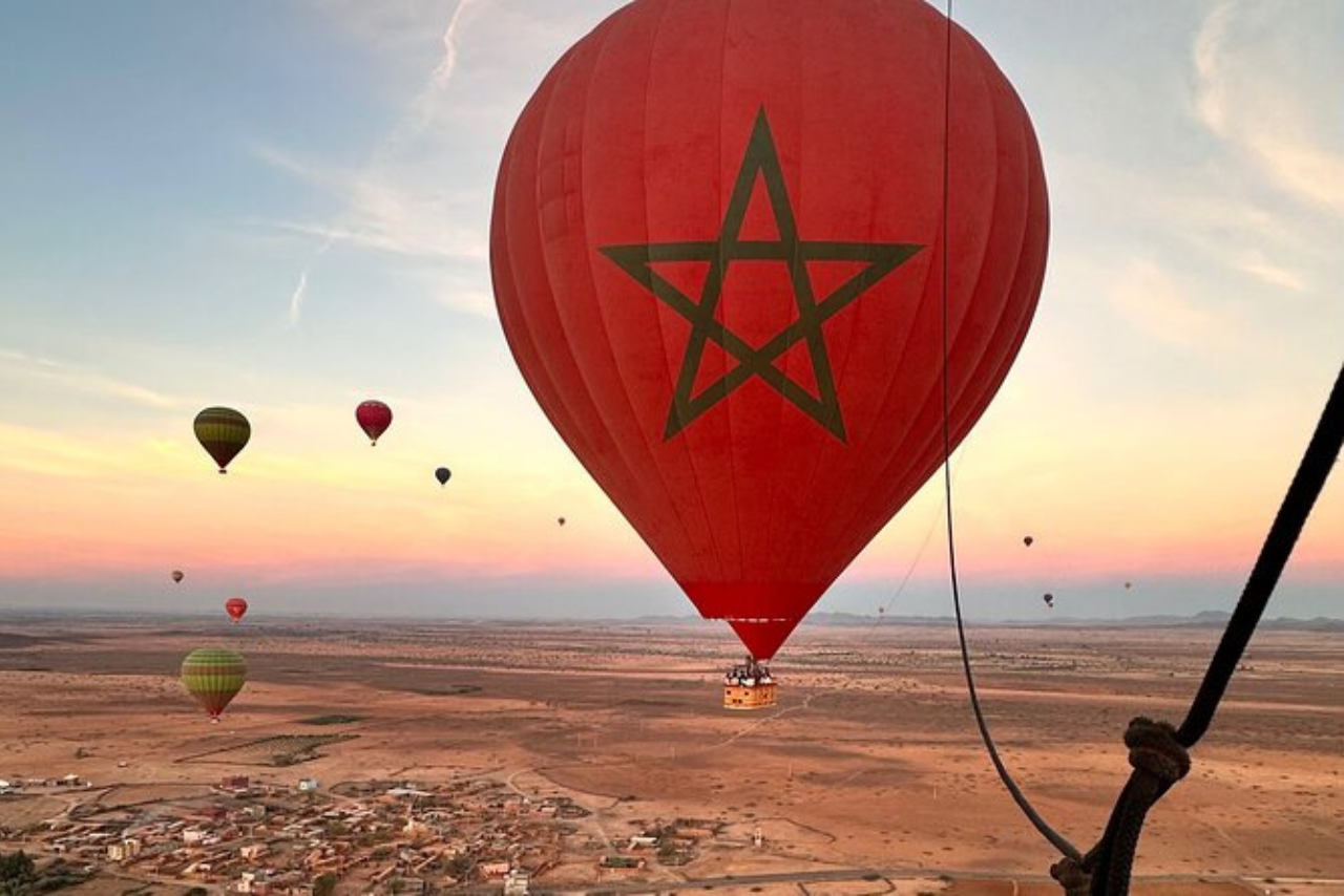 Spectacular view of hot air balloons rising over the Marrakech Palmeraie at sunrise for a premium sightseeing tour.